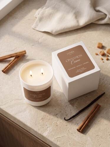 Cinnamon-Creme-Sojakerze mit zwei Flammen neben Verpackung, Zimt, Vanille und Karamell